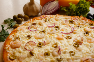 Hot italian pizza on a table with vegetables