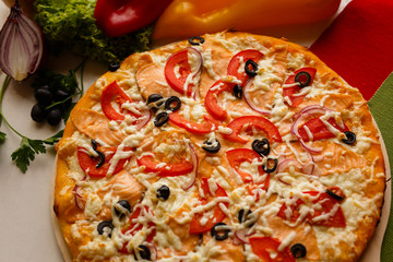 Hot italian pizza on a table with vegetables