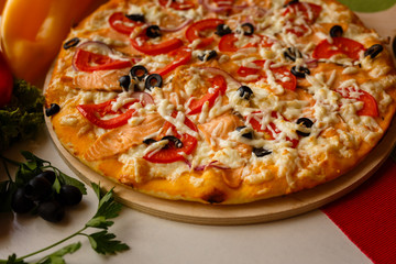 Hot italian pizza on a table with vegetables