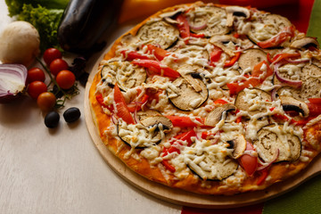 Hot italian pizza on a table with vegetables