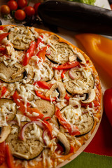 Hot italian pizza on a table with vegetables