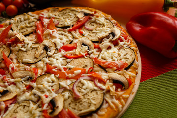Hot italian pizza on a table with vegetables