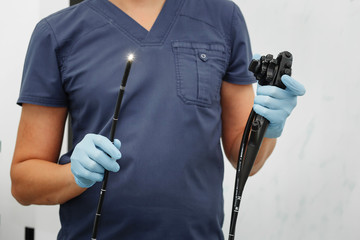 Doctor endoscopist holds an endoscope with hands in gloves