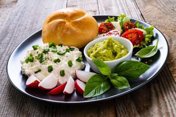 Breakfast - cottage cheese, bun, guacamole and vegetables
