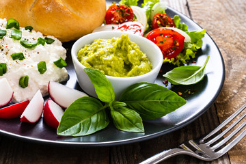 Breakfast - cottage cheese, bun, guacamole and vegetables
