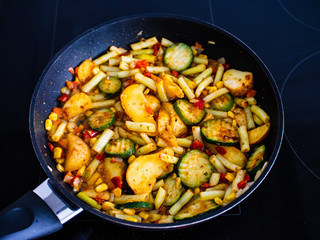 Frying various vegetables in pan
