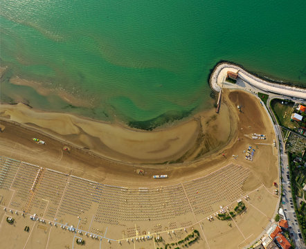 Spiaggia di Caorle in estate con ombrelloni e lidi con vista  mare dall'alto