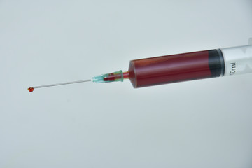 Syringe and needle filled with blood.