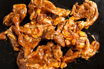 A picture of marinated black pepper and herbs mutton on black tray.