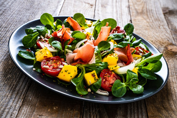 Tasty salad - ham and vegetables on wooden background