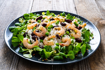 Prawns with rice and vegetables on wooden table