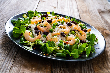 Prawns with rice and vegetables on wooden table