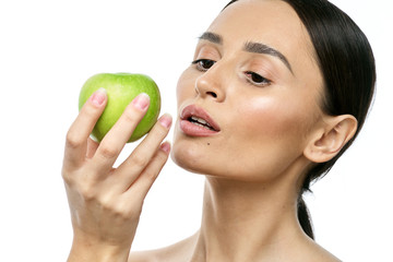 close-up portrait of a girl with clear skin holding a apple to her face, isolated on a white background