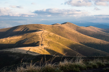 Panorama of a view of hills of a smoky mountain range covered in white mist and deciduous forest under blue cloudless sky on a warm fall day