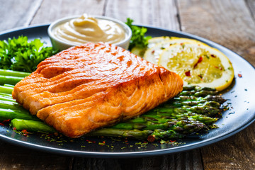 Fried salmon and asparagus on wooden table
