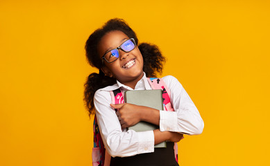 Smiling Black Schoolgirl Hugging Book Missing School, Studio Shot