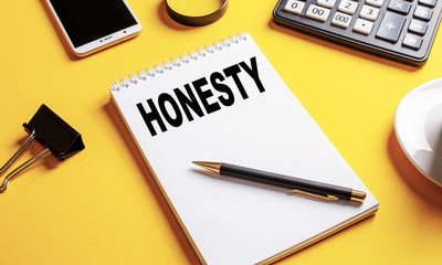 The word honesty is written in a white Notepad on a yellow background.