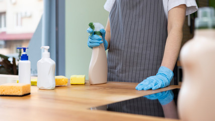 Woman making cleaning with eco spray detergent in rubber gloves