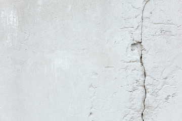 Texture and background. White old concrete wall with a crack
