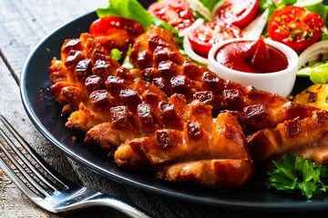 Grilled sausages and vegetables on wooden board
