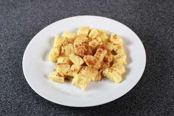 Gnocchi. Small soft dough dumplings with cottage cheese, honey and cinnamon on plate.