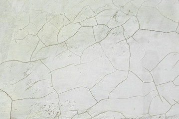 White concrete wall with cracks and scratches. Texture of scratched, old and worn wall close up.