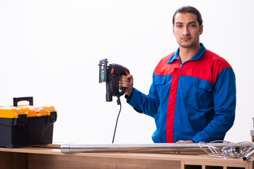 Young handsome male carpenter working indoors