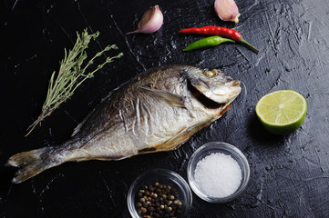 fresh grilled fish on a black Board, top view