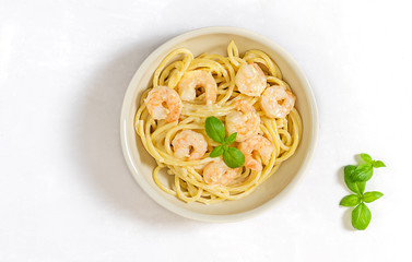 Bucatini thick spaghetti italian pasta with garlic cream sauce and shrimps. Top view, copy space