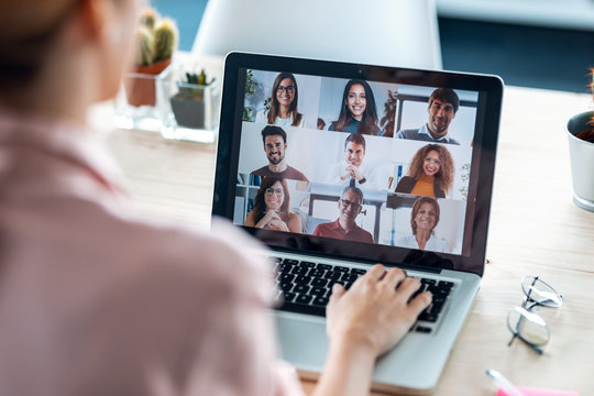 Female employee speaking on video call with diverse colleagues on online briefing with laptop at home.