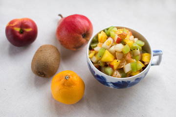 fruit salad serving in a Cup decanter milkman with fresh milk yogurt isolate on a white background kiwi nectarine pear Mandarin