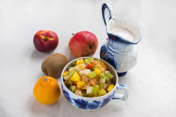 fruit salad serving in a Cup decanter milkman with fresh milk yogurt isolate on a white background kiwi nectarine pear Mandarin