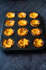 Pasteis de Nata or Belem Tart. Portuguese Custard made with Egg, Cinnamon, Sugar and Flour in Muffin Tray / Cupcake Mold.
