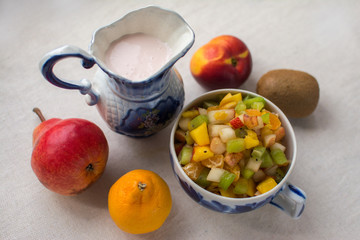 fruit salad serving in a Cup decanter milkman with fresh milk yogurt isolate on a white background kiwi nectarine pear Mandarin