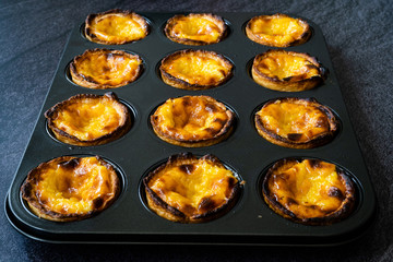 Pasteis de Nata or Belem Tart. Portuguese Custard made with Egg, Cinnamon, Sugar and Flour in Muffin Tray / Cupcake Mold.