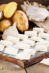 raw dumplings with potatoes and mushrooms on the board
