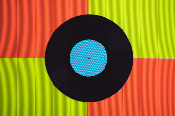 Black vinyl arranged on a red and green background seen from above