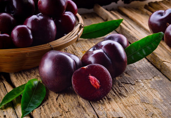 Plums isolated on a wooden background