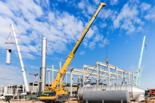 Cranes are installing equipment on the construction site of the new factory