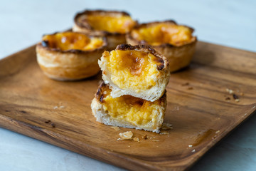 Pasteis de Nata or Belem Tart. Portuguese Custard made with Egg, Cinnamon, Sugar and Flour on Wooden Plate.