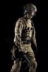 Soldier holding assault rifle. Uniform conforms to special services of the Russian Federation. Shot in studio. Isolated with clipping path on black background