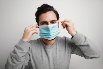 Portrait of young man using medical virus mask protection of coronavirus. Worldwide pandemic situation. Space for text.