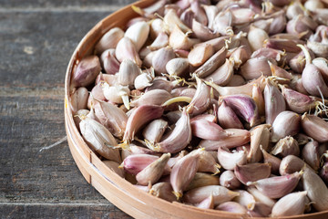 Garlic cloves on bamboo basket tray.