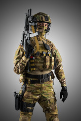 Soldier holding assault rifle. Uniform conforms to special services of the Russian Federation. Shot in studio. Isolated with clipping path on grey background
