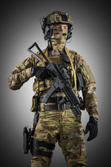 Soldier holding assault rifle. Uniform conforms to special services of the Russian Federation. Shot in studio. Isolated with clipping path on grey background
