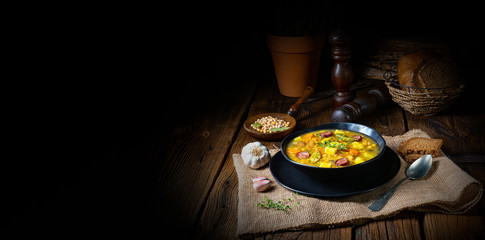 Rustic pea soup with bacon and sausages