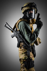Soldier holding assault rifle. Uniform conforms to special services of the Russian Federation. Shot in studio. Isolated with clipping path on grey background