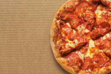 Pizza pepperoni on corrugated fiberboard background.