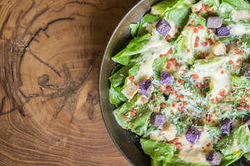 Caesar salad on wooden table at the restaurant.