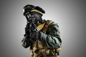 Soldier holding assault rifle. Uniform conforms to special services of the Russian Federation. Shot in studio. Isolated with clipping path on grey background